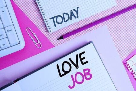 Handwriting text Love Job. Conceptual photo designed to help locate a fulfilling job that is right for us Writing equipments and computer stuffs placed above colored plain tableの写真素材