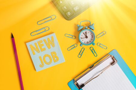 Writing note showing New Job. Business concept for able to get regular work in order to earn money and support life Alarm clock clipboard pencil calculator notepad colored backgroundの写真素材