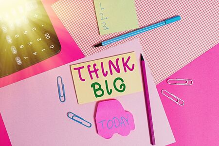 Conceptual hand writing showing Think Big. Concept meaning To plan for something high value for ones self or for preparation writing equipments and plain note paper placed on the tableの写真素材