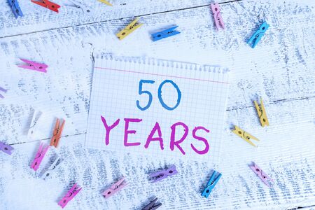 Word writing text 50 Years. Business photo showcasing Honoring Ruby Jubilee Commemorating a special day Semicentennial Colored clothespin rectangle square shaped paper white wood backgroundの写真素材
