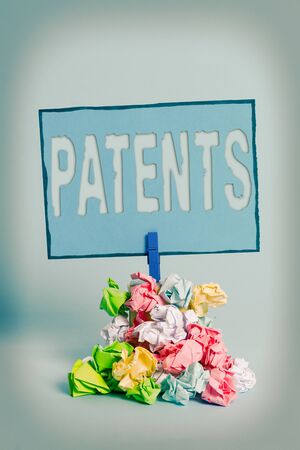 Writing note showing Patents. Business concept for government authority or licence conferring a right or title Reminder pile colored crumpled paper clothespin wooden spaceの写真素材