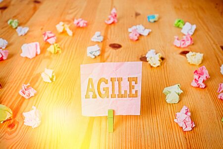 Text sign showing Agile. Business photo showcasing particular approach to project management that is utilized in software Colored crumpled papers empty reminder wooden floor background clothespinの写真素材