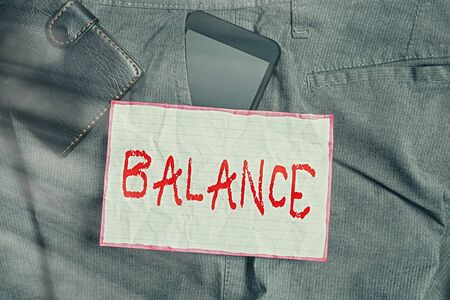 Text sign showing Balance. Business photo showcasing a state of equilibrium or equipoise Living with peace and harmony Smartphone device inside trousers front pocket with wallet and note paperの写真素材