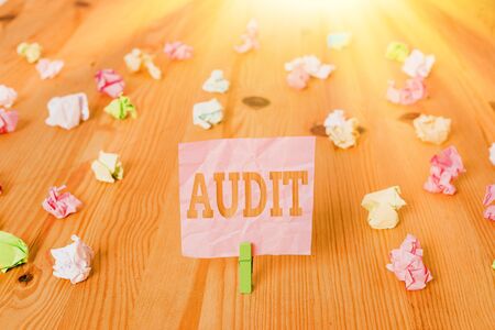 Text sign showing Audit. Business photo showcasing Distinctive typically pleasant smell Subtle of a particular type Colored crumpled papers empty reminder wooden floor background clothespinの写真素材