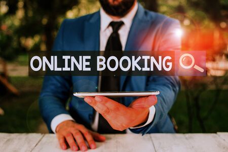 Text sign showing Online Booking. Business photo showcasing tool used to analysisage business travel through internet Businessman with mobile phone in his handの写真素材
