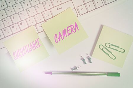 Conceptual hand writing showing Surveillance Camera. Concept meaning Closed Circuit Television transmit signal on monitors Empty note paper and paper clips with pencil on white backgroundの写真素材