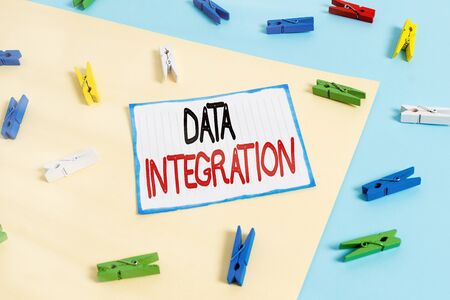 Conceptual hand writing showing Data Integration. Concept meaning combination of technical and business processes to combine Colored clothespin paper reminder with yellow blue backgroundの写真素材