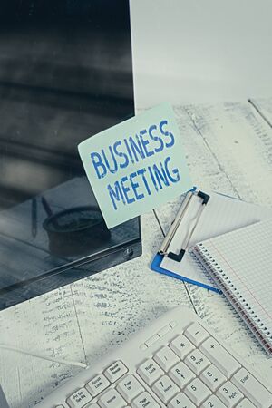 Word writing text Business Meeting. Business photo showcasing used discuss issues that cannot be addressed in simple way Note paper taped to black computer screen near keyboard and stationaryの写真素材