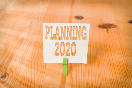 Handwriting text Planning 2020. Conceptual photo Begin with end in the Mind Positioning Long term Objectives Empty reminder wooden floor background green clothespin groove slot officeの写真素材