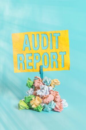 Handwriting text Audit Report. Conceptual photo An appraisal of complete financial status of a business Assets Reminder pile colored crumpled paper clothespin reminder blue backgroundの写真素材
