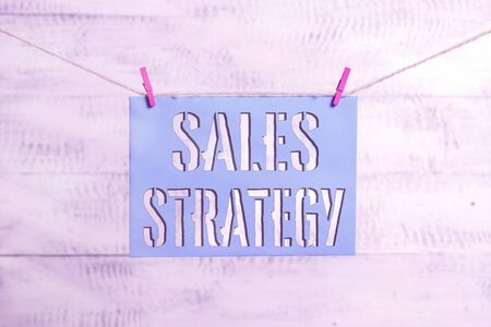Handwriting text Sales Strategy. Conceptual photo Plan for reaching and selling to your target market Marketing Clothesline clothespin rectangle shaped paper reminder white wood deskの写真素材