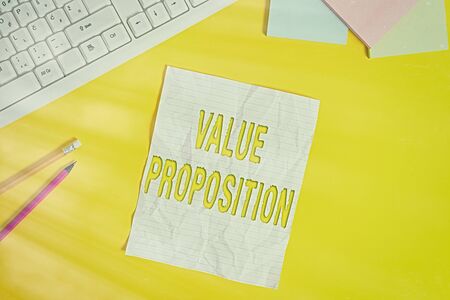 Word writing text Value Proposition. Business photo showcasing innovation service intended make product attractive Copy space on notebook above yellow background with pc keyboard on the tableの写真素材