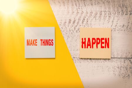 Text sign showing Make Things Happen. Business photo showcasing you will have to make hard efforts in order to achieve it Two multicolor blank notepads colored paper sheet retro wooden backgroundの写真素材