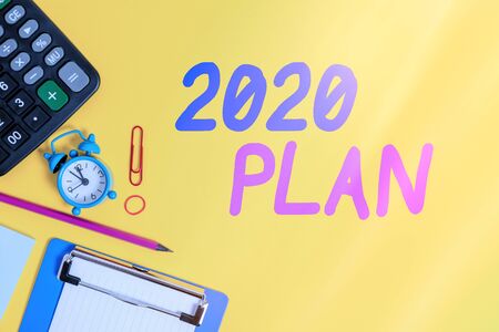 Text sign showing 2020 Plan. Business photo showcasing setting up your goals and plans for the current year or in 2020 Clock clips crushed note calculator pencil clipboard band color backgroundの写真素材