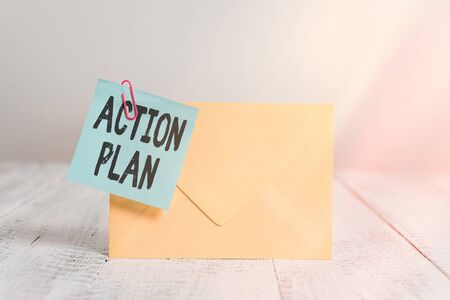 Text sign showing Action Plan. Business photo text detailed plan outlining actions needed to reach goals or vision Standing rectangular colored envelope sticky note clip wooden backgroundの写真素材