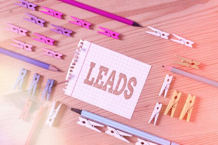Writing note showing Leads. Business concept for demographic information of customer interested in specific product Colored clothespin papers empty reminder wooden floor background officeの写真素材