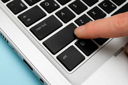 Pc keyboard key with pointing finger above background copy space