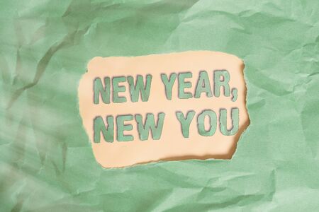 Writing note showing New Year, New You. Business concept for coming January Changing an individualality for a better an individual Green crumpled colored paper sheet torn colorful backgroundの写真素材