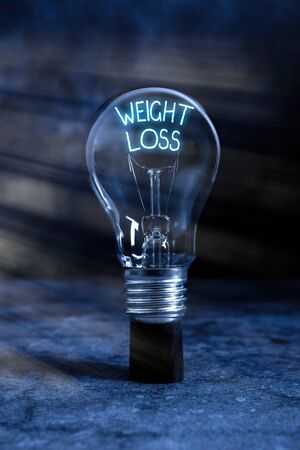 Text sign showing Weight Loss. Business photo text a reduction of the total body mass due to a mean loss of fluid Realistic colored vintage light bulbs, idea sign solution thinking conceptの写真素材