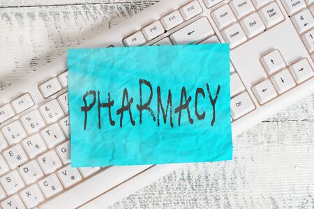 Text sign showing Pharmacy. Business photo text the practice of prescription drug preparation and dispensing White keyboard office supplies empty rectangle shaped paper reminder woodの写真素材