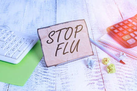 Word writing text Stop Flu. Business photo showcasing put an end of the viral infection of your lungs and airways Notepaper stand on buffer wire in between computer keyboard and math sheetsの写真素材