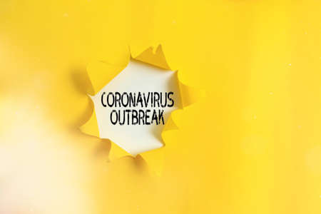 Handwriting text Coronavirus Outbreak. Conceptual photo infectious disease caused by newly discovered COVID19 Rolled ripped torn cardboard placed above a wooden classic table backdropの写真素材