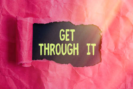 Text sign showing Get Through It. Business photo text encourage someone to succeed in passing or surviving Rolled ripped torn cardboard placed above a wooden classic table backdropの写真素材