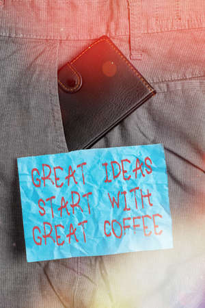 Text sign showing Great Ideas Start With Great Coffee. Business photo showcasing have a hot drink to get inspired Small little wallet inside man trousers front pocket near notation paperの写真素材