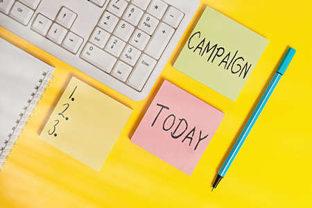 Conceptual hand writing showing Campaign. Concept meaning connected operations designed to bring about a particular result Empty papers with copy space on yellow background tableの写真素材