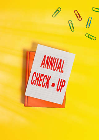 Text sign showing Annual Checkup. Business photo text yearly reproductive health visit with a health care provider Paper clips with blank papers for text messagesの写真素材
