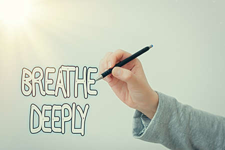 Text sign showing Breathe Deeply. Business photo text to take a lot of air into the lungs inhaleexhale fully Model displaying different shots of holding pen ready for promotional useの写真素材