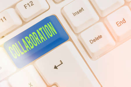 Text sign showing Collaboration. Business photo showcasing cooperate with or willingly assist an enemy of one s is country Different colored keyboard key with accessories arranged on empty copy spaceの写真素材