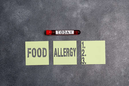 Conceptual hand writing showing Food Allergy. Concept meaning abnormal immune system response to allergen after eaten Blood sample vial medical accessories ready for examinationの写真素材
