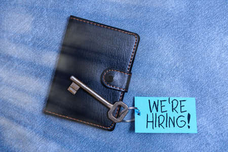 Text sign showing We Re Hiring. Business photo text process of reviewing applications and finding candidates Paper accesories with digital smartphone arranged on different backgroundの写真素材