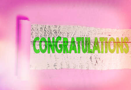 Text sign showing Congratulations. Business photo showcasing a congratulatory expression usually used in plural form Rolled ripped torn cardboard placed above a wooden classic table backdropの写真素材