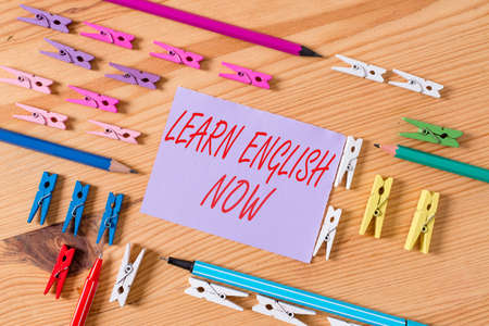 Text sign showing Learn English Now. Business photo text gain or acquire knowledge and skill of English language Colored clothespin papers empty reminder wooden floor background officeの写真素材