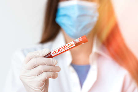 Text sign showing Volunteering. Business photo text an individual who voluntarily expresses a willingness to undertake Laboratory blood test sample shown for medical diagnostic analysis resultの写真素材