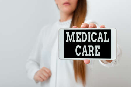 Conceptual hand writing showing Medical Care. Concept meaning the professional attention of medical practitioners in health Model displaying black screen modern smartphone mock-upの写真素材