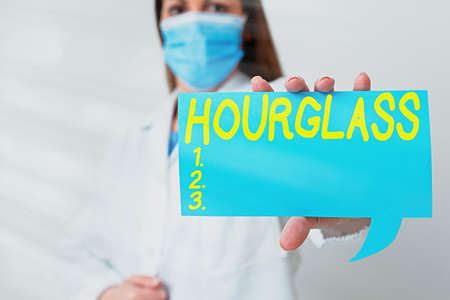 Conceptual hand writing showing Hourglass. Concept meaning instrument for measuring time consisting of a glass vessel Laboratory technician featuring paper accessories smartphoneの写真素材