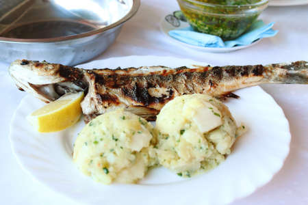 Roasted fish with potatoes in Croatian restaurantの写真素材