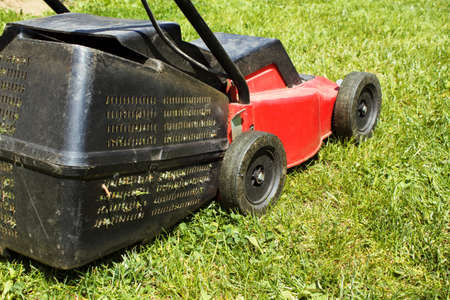 lawnmower on green grass in sunny day