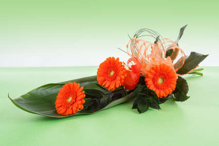 fresh bouquet from orange gerbers on green background の写真素材