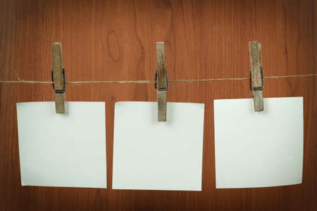 white memory note paper hanging on cord on wooden backgroundの写真素材
