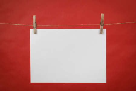 Memory note white paper hanging on cord on red backgroundの写真素材