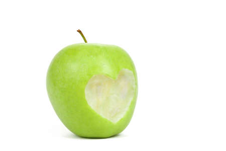 Fresh green apple with cut off heart shape on white backgroundの写真素材