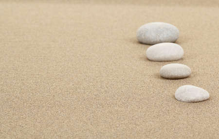 four zen stones in sand as background or backdropの写真素材