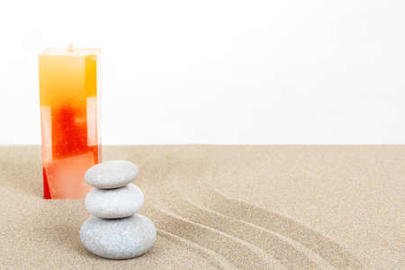 Balance zen stones and candle in sand on white backgroundの写真素材