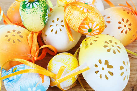 Bright color easter eggs with bows on wooden desk
