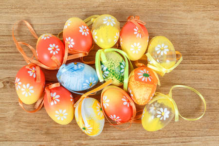 Bright color easter eggs with bows on wooden desk