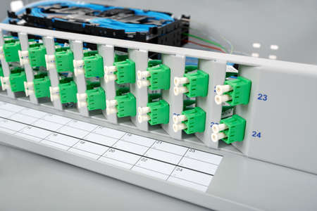 stack of fiber optic cassettes installed in optical distribution frame and green LC connectorsの写真素材